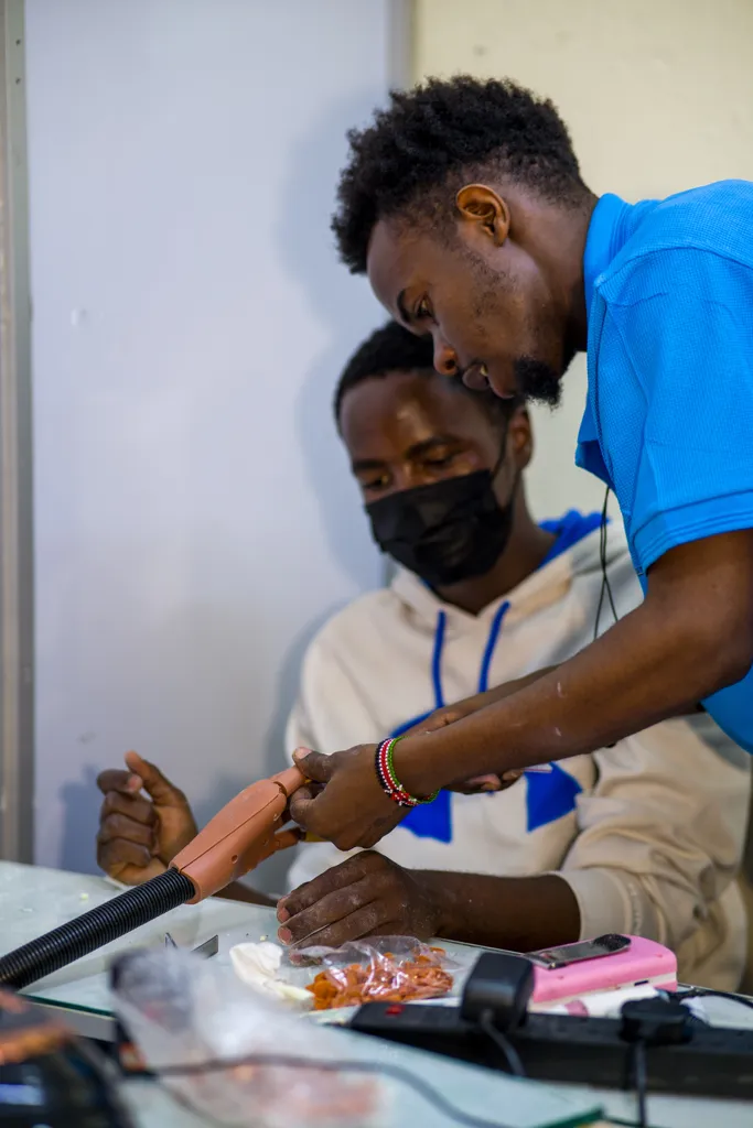 Teacher guiding a nail student during a training session